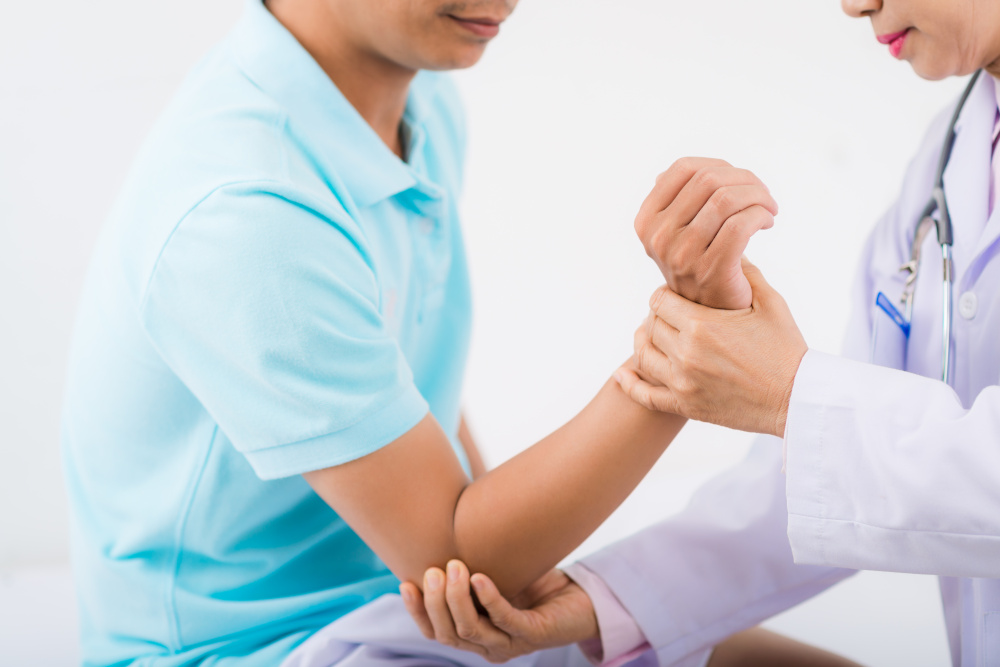 ortopeda który bada ręke małemu pacjentowi